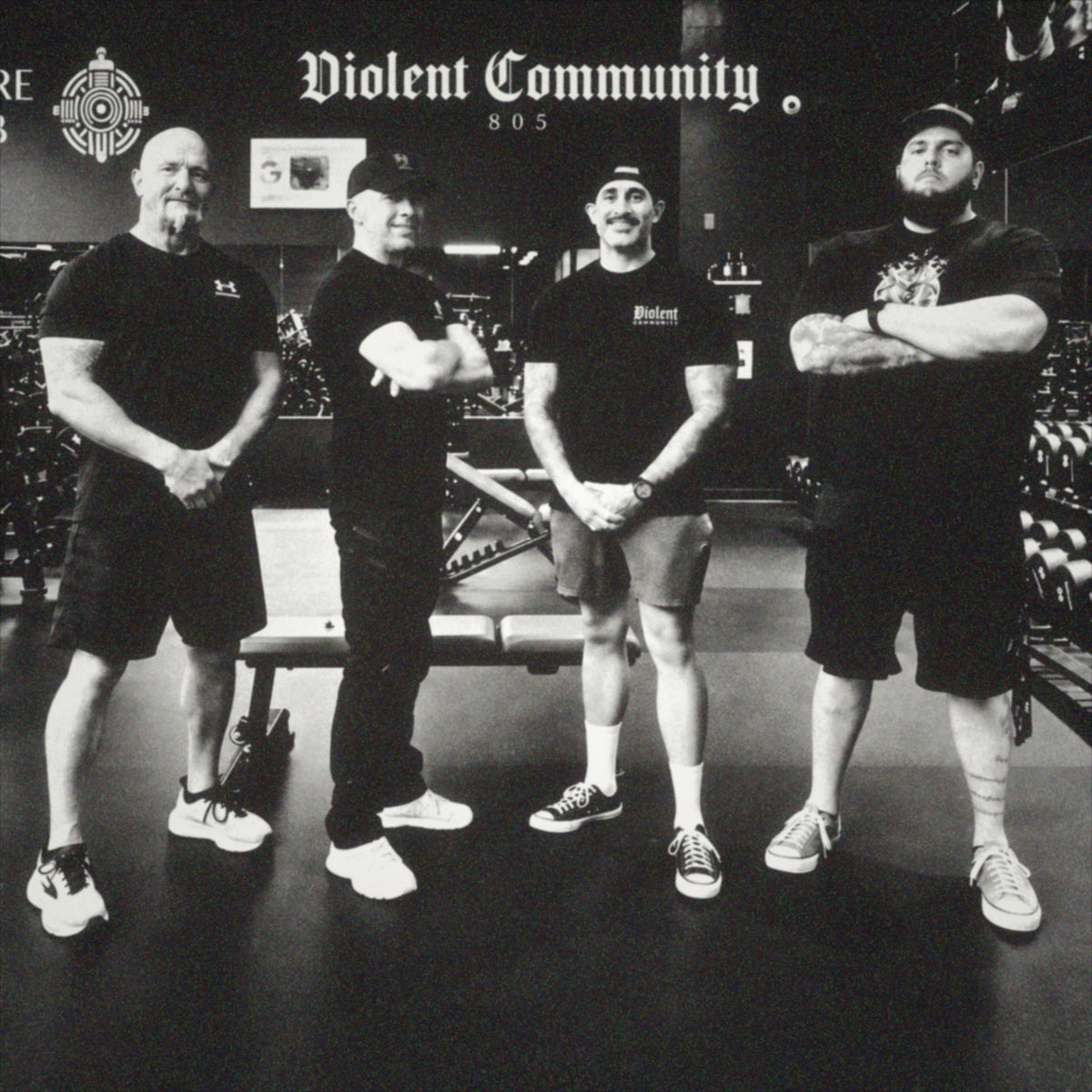 Four Violent Community members at the gym in a grainy black-and-white photo