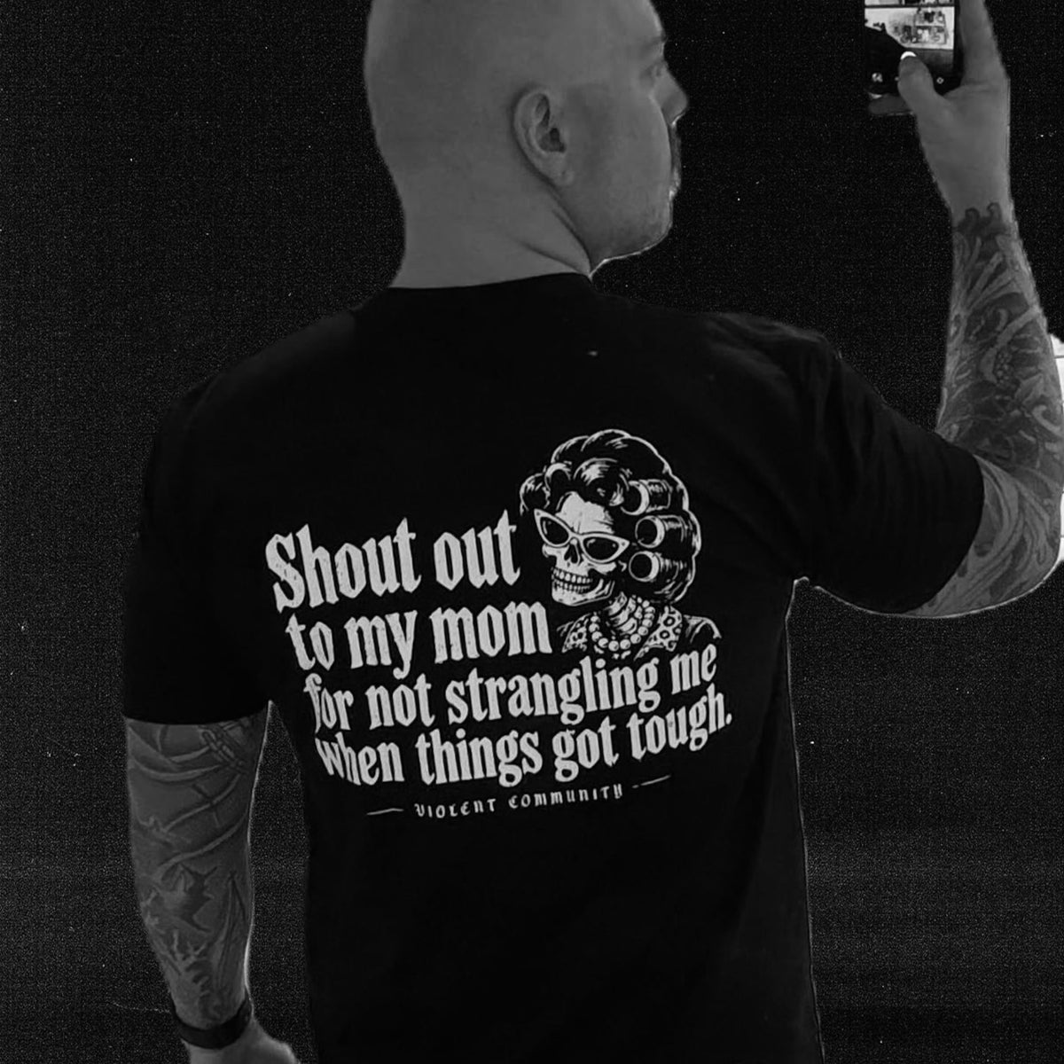 Community member wearing the Shout Out to My Mom shirt with its back print visible